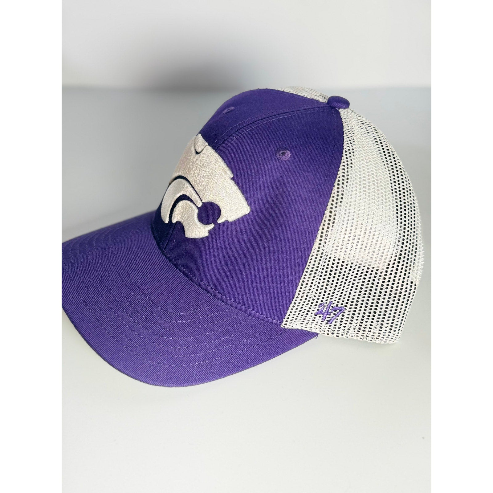 '47 Brand Kansas State Wildcats trucker hat in purple and white with adjustable strap, NCAA logo, and embroidered team graphics.