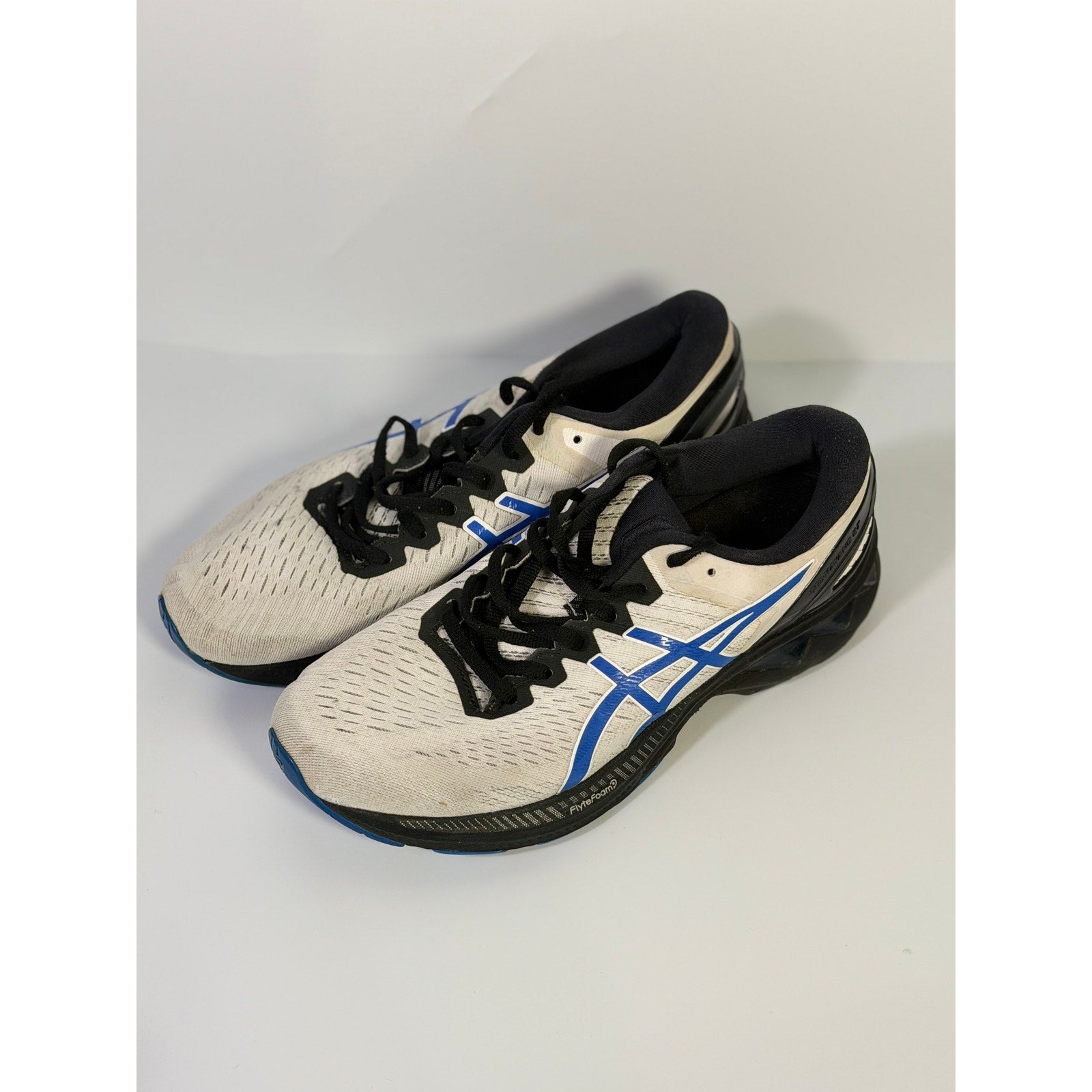 Asics Gel Cumulus 24 men's white, blue, and black running sneakers, athletic shoes with cushioned design and supportive sole.