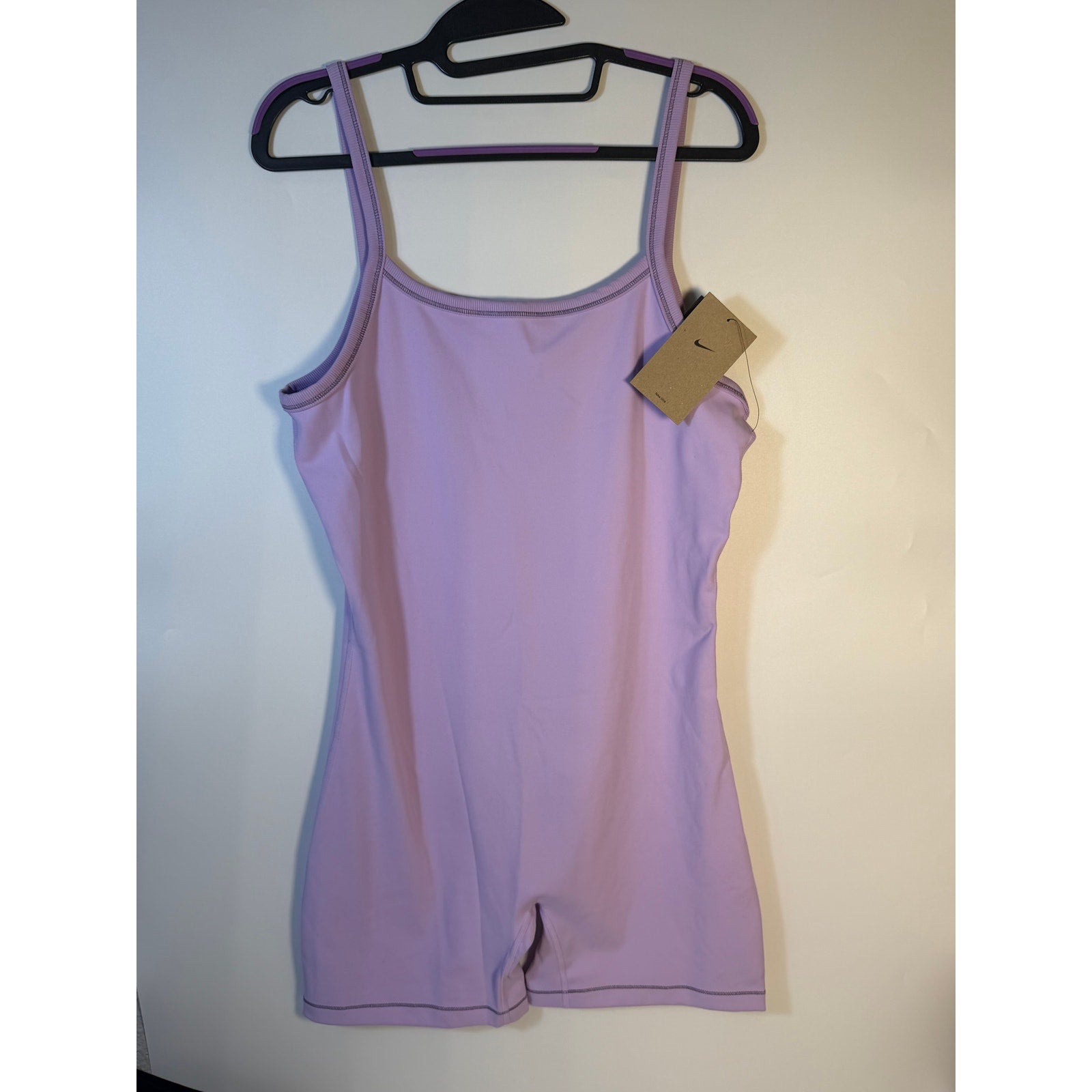 Lavender Nike One Dri-FIT training romper bodysuit for women, large size, displayed on a hanger or model.