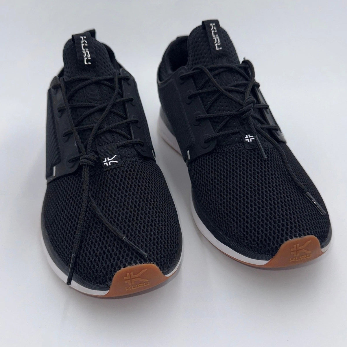 KURU ATOM Women's medium jet black and white gum supportive walking sneakers with cushioned soles and sporty design.