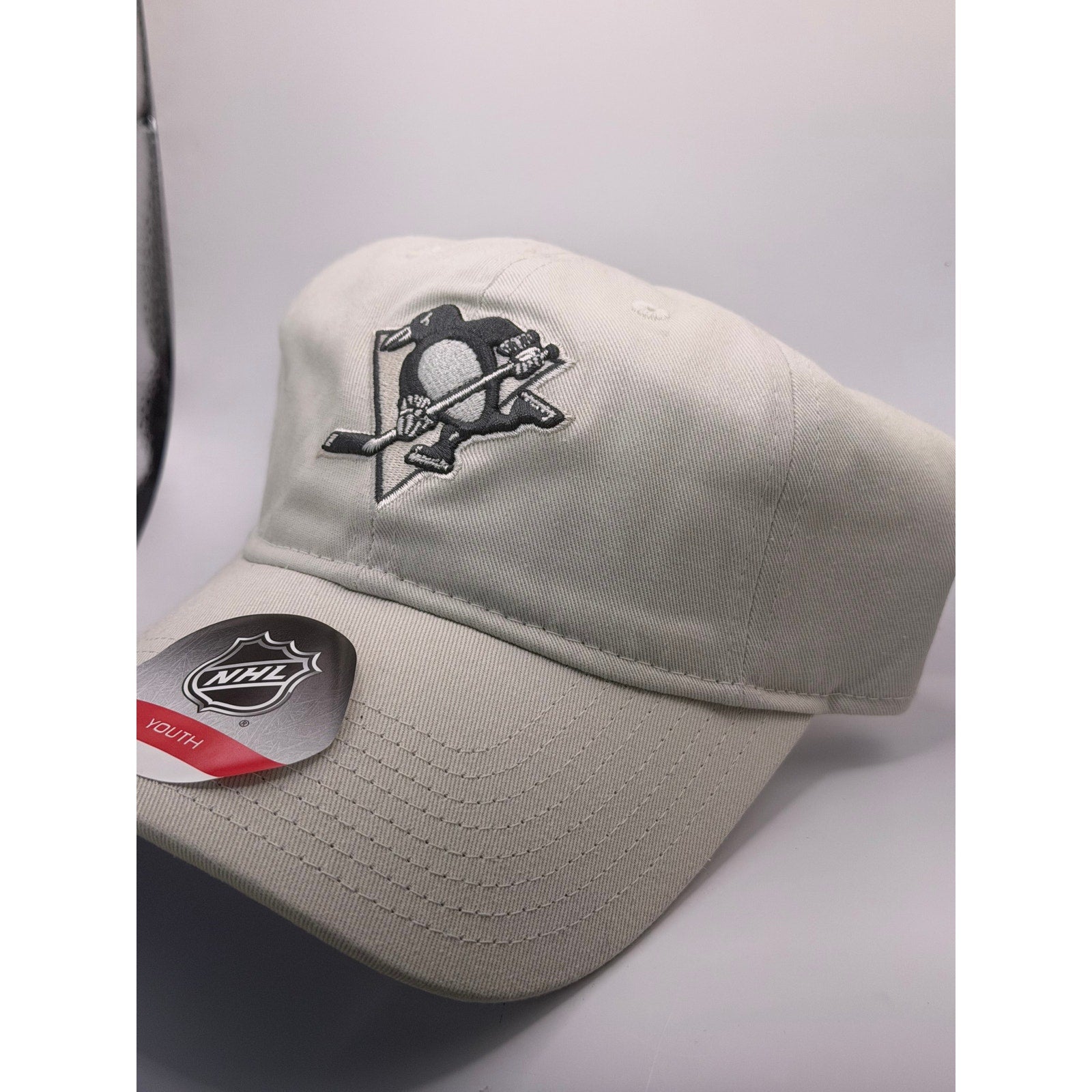 NHL Pittsburgh Penguins youth adjustable strapback cap in beige, featuring team logo and one size fits most.