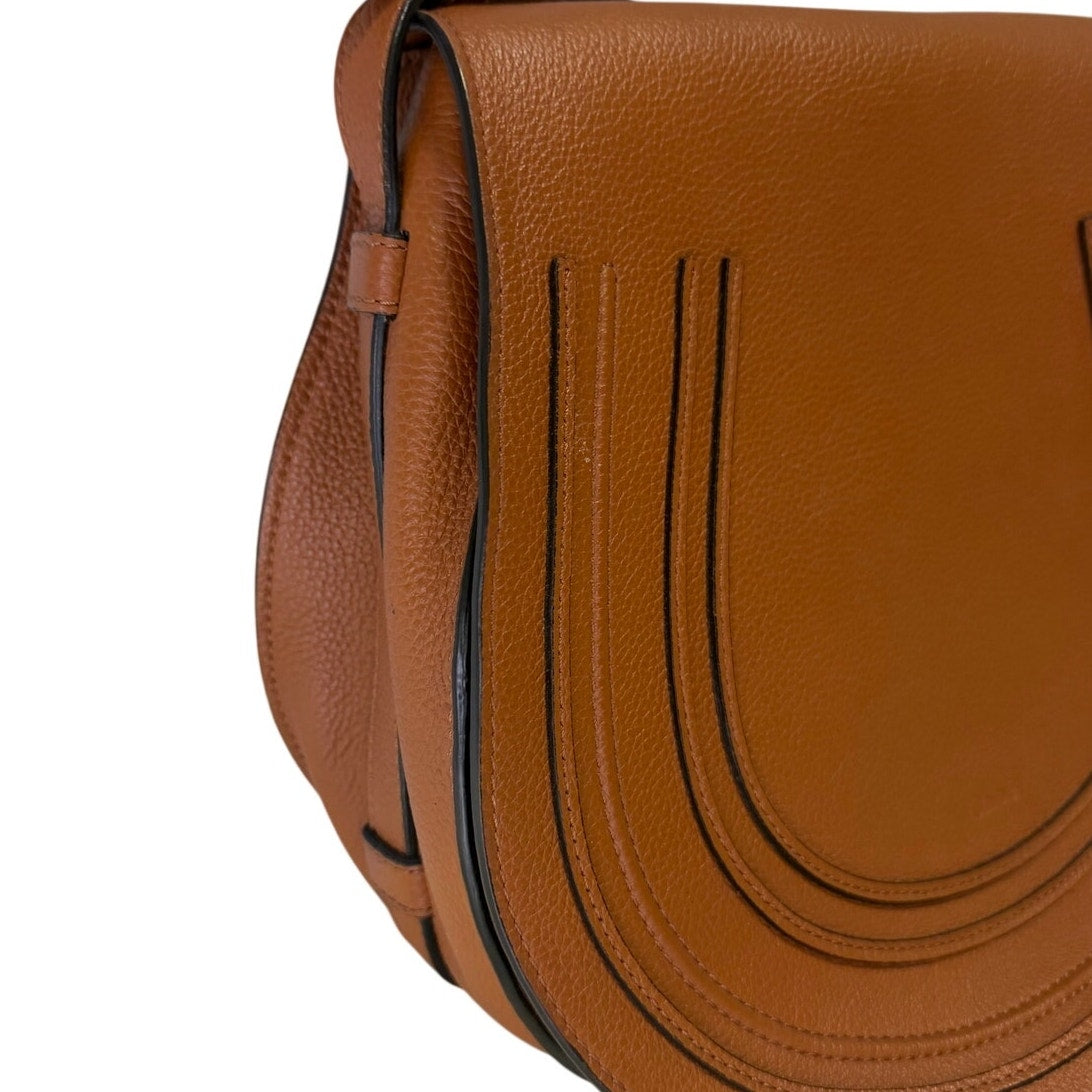 Chloé Marcie medium saddle crossbody handbag in brown grained calfskin leather with gold hardware, featuring a classic design.
