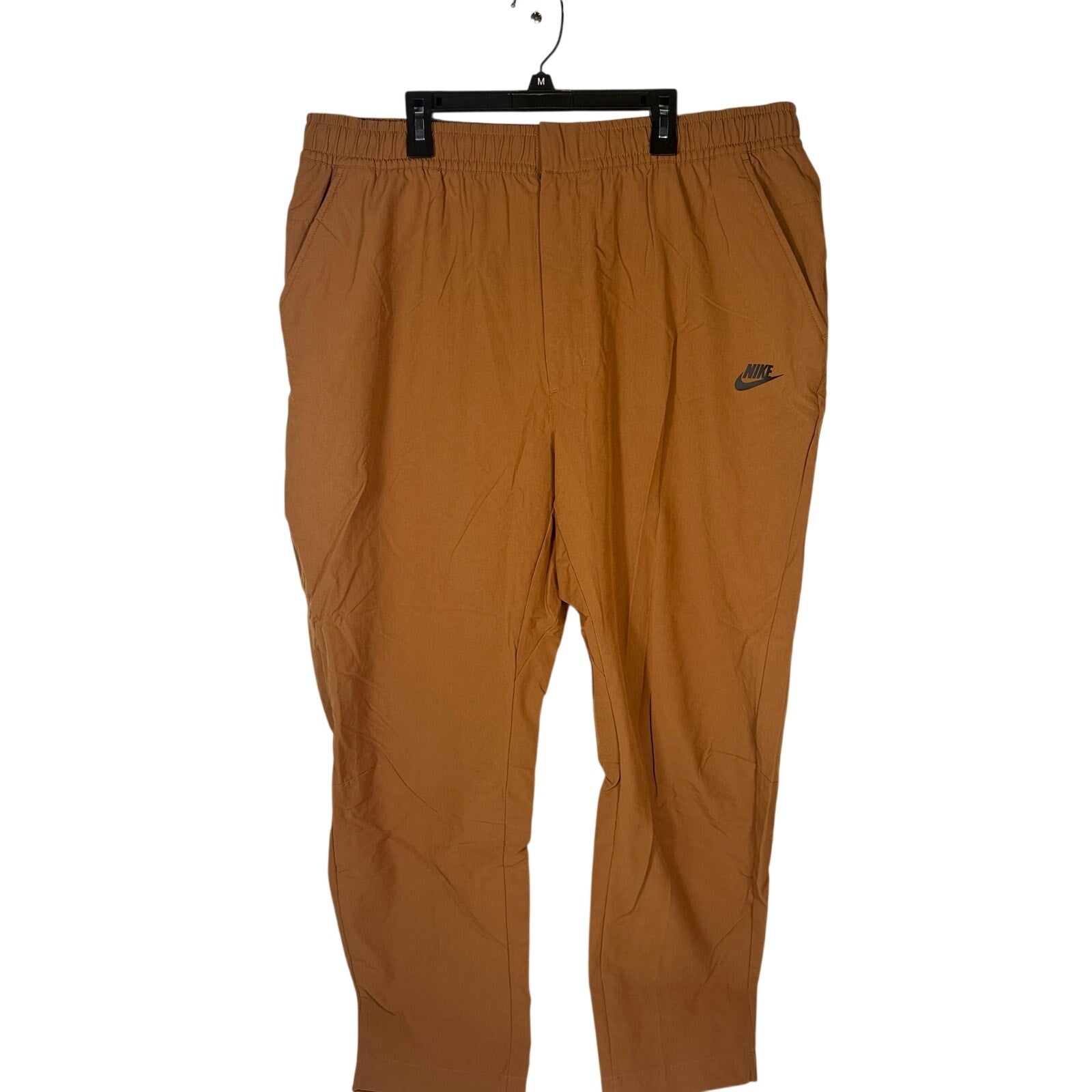 Nike Sportswear men's woven pants in brown cacao with elastic waist, size XXL, featuring a relaxed fit and casual style.