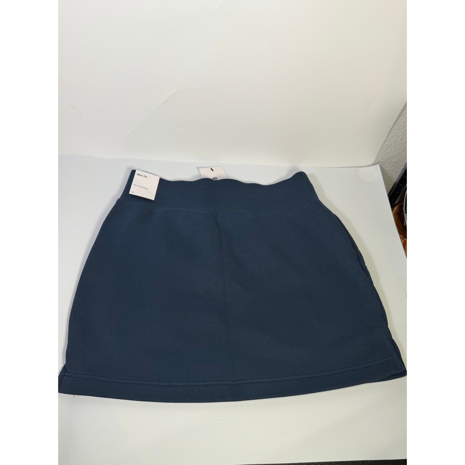 Nike women's navy blue fleece drawstring mini skirt, front view showing fit and fabric texture, size M.