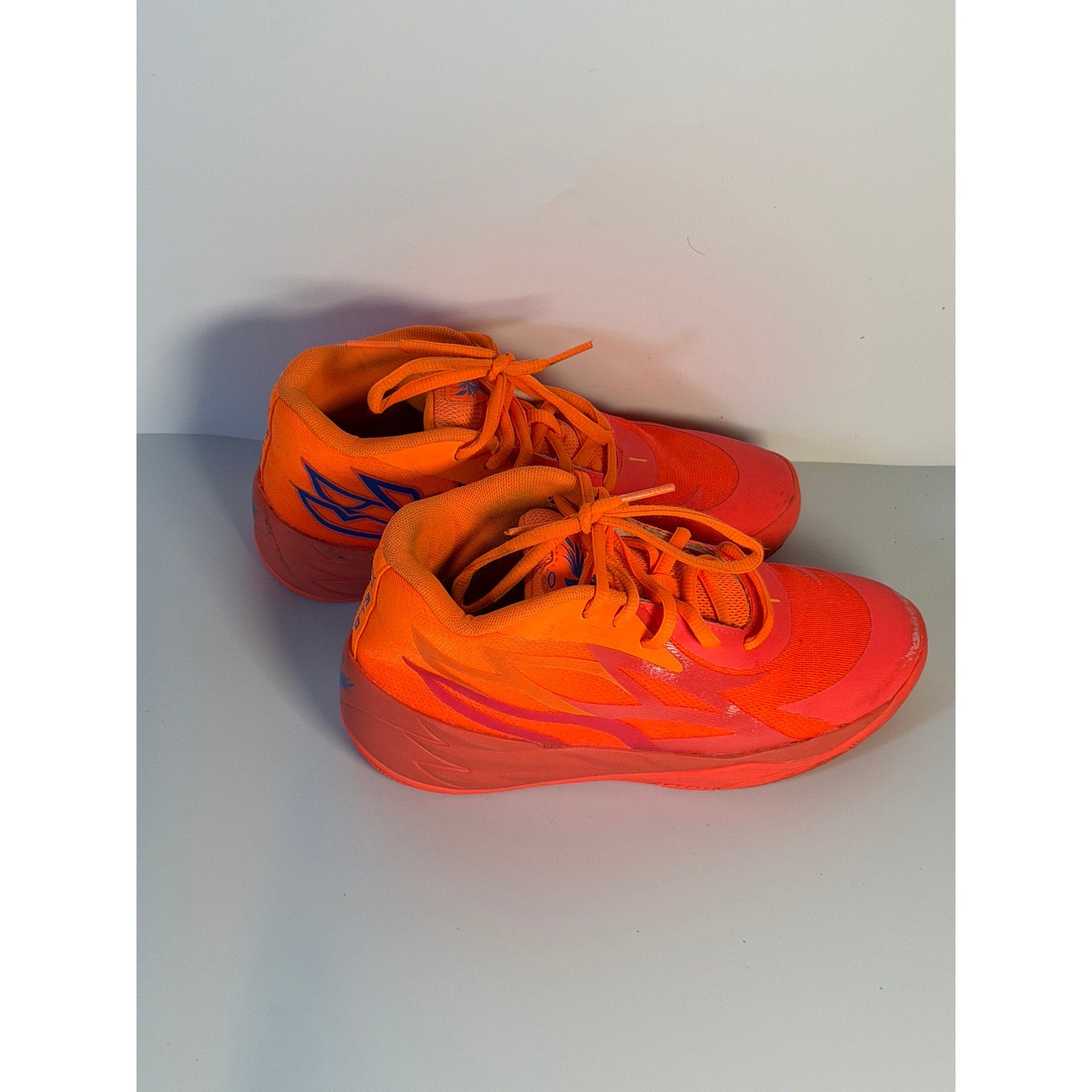 PUMA MB.02 Lo men's basketball shoes in orange and pink with black accents, size 5.5, athletic sneakers on a white background.