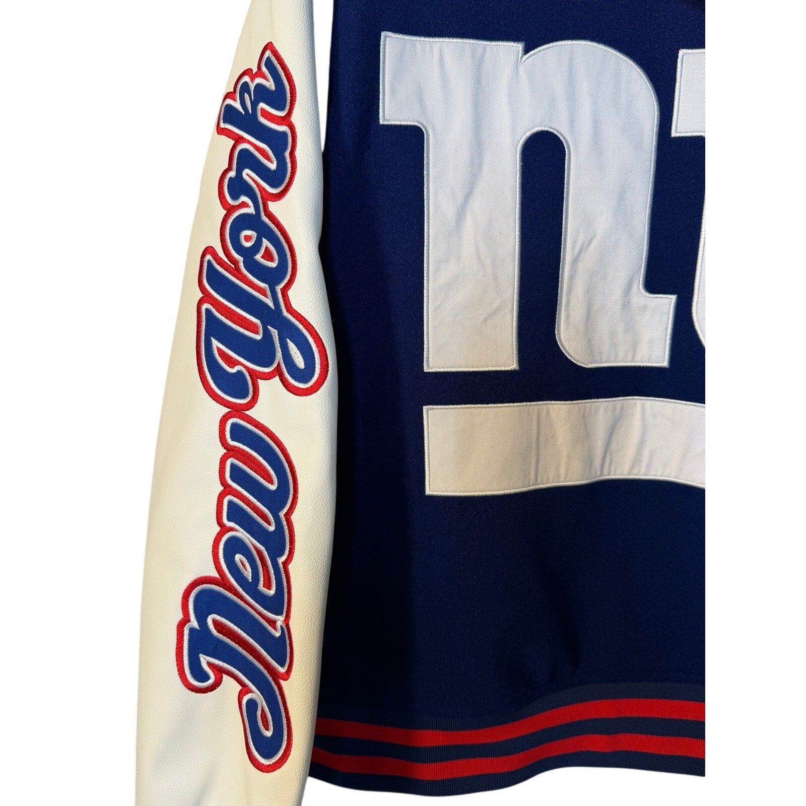 Men’s New York Giants NFL varsity jacket with team logo, ribbed cuffs, collar, and button closure in medium size.