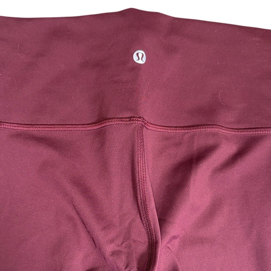 Lululemon women’s burgundy high-rise flared yoga leggings size 6, showing the fitted waistband and flared leg design.