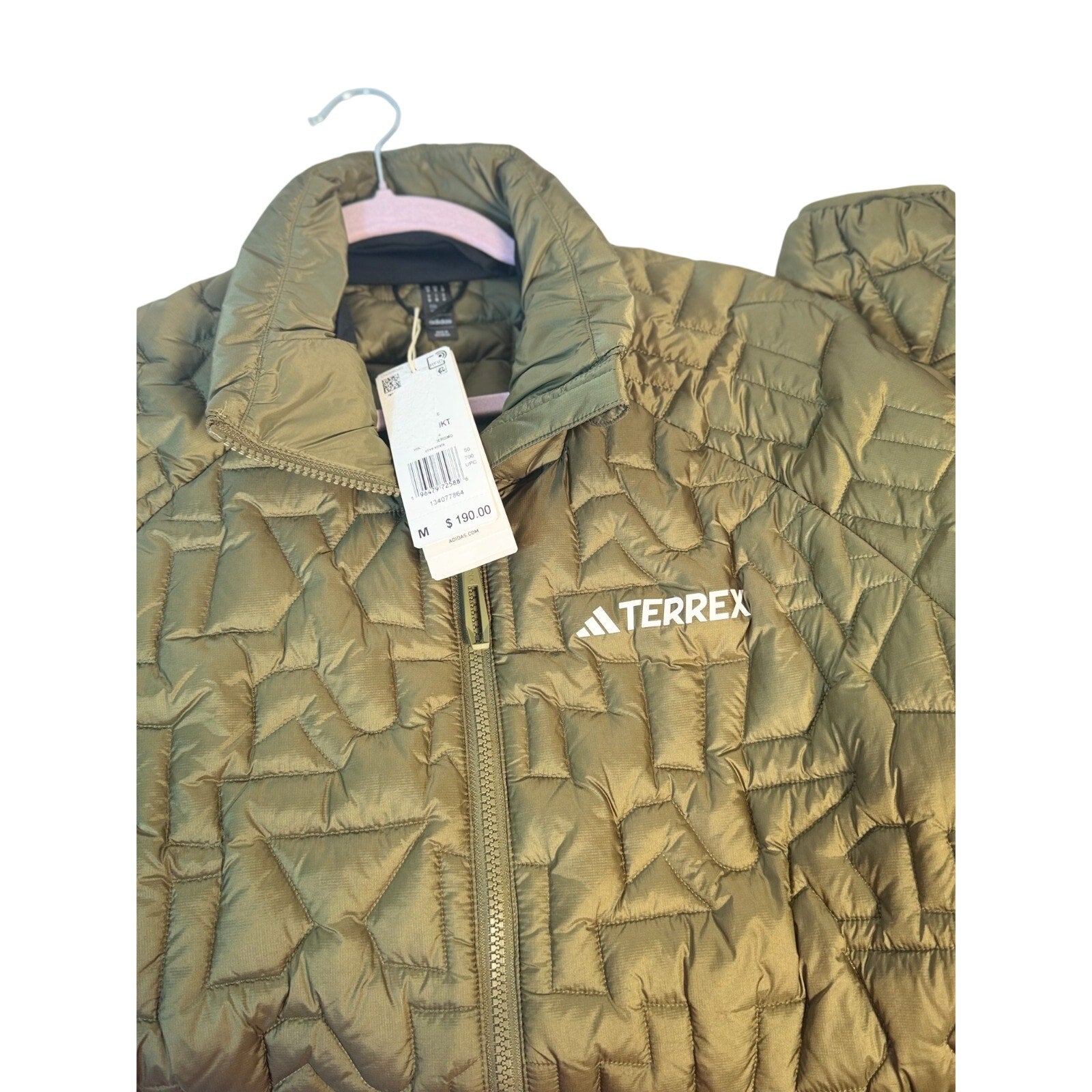 Men's Adidas Terrex insulated puffer jacket in olive green, displayed on a hanger with a high collar and quilted design.