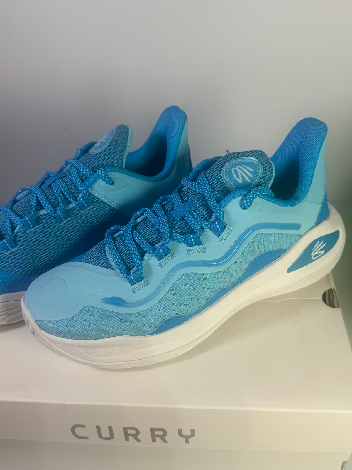 Under Armour Curry Flow basketball shoes in blue for youth size 7Y, featuring sporty design and athletic performance.