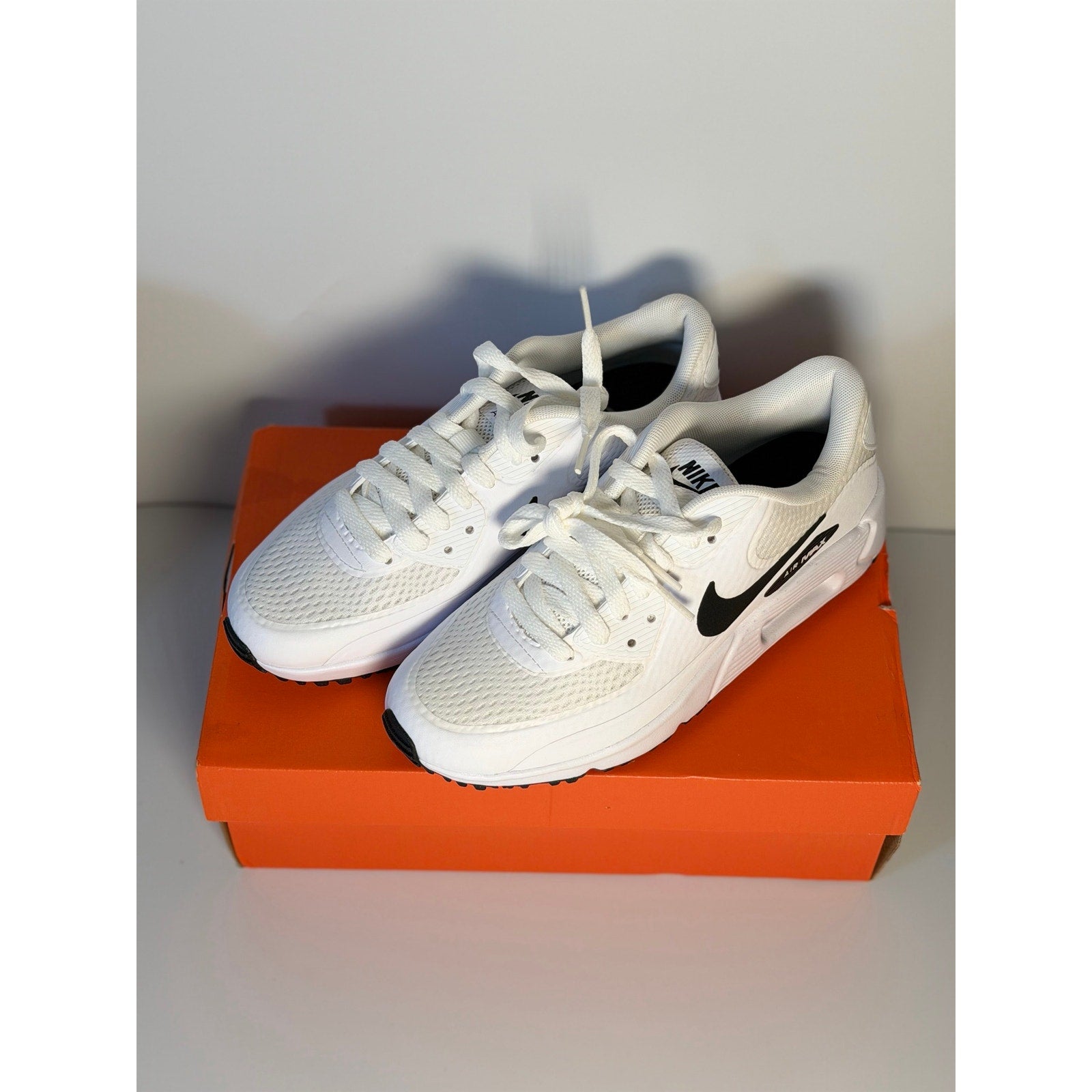 Nike Air Max 90 G golf shoes in white and black for men and women, featuring sporty design and Nike branding.