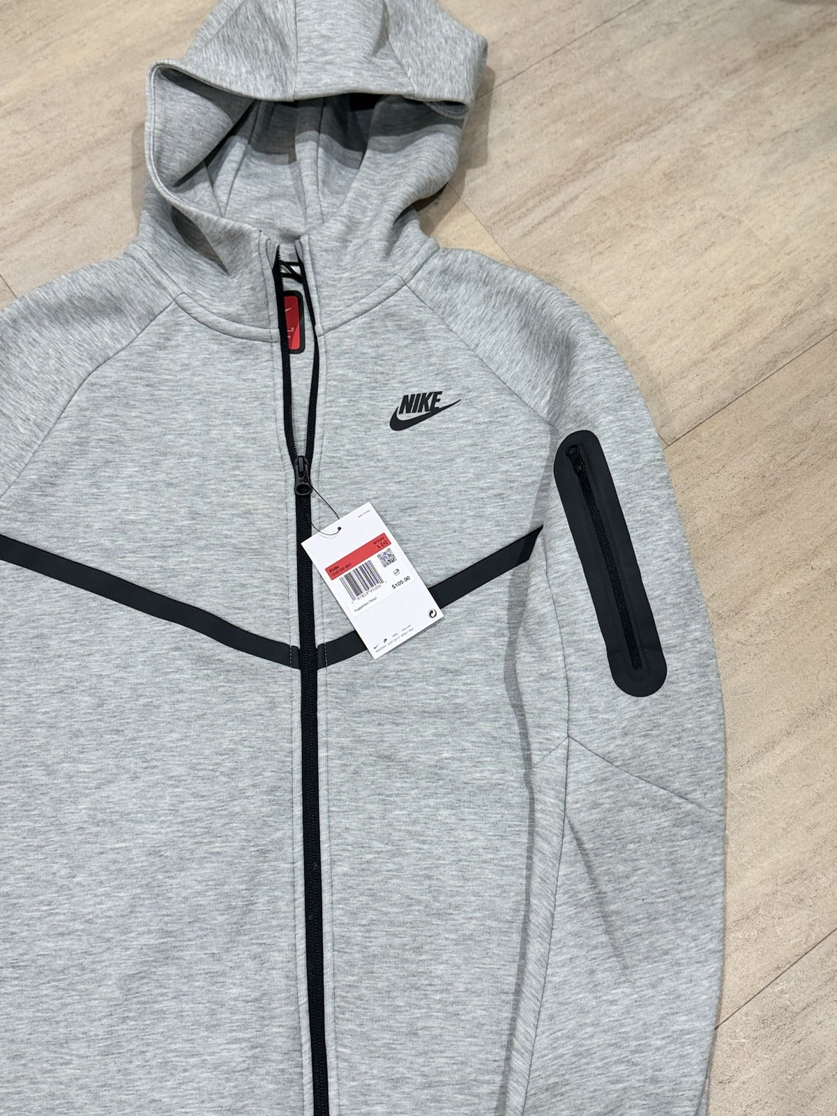 Nike Tech Fleece full-zip hoodie for big kids in dark grey heather, size L, with black accents, Nike branding visible.