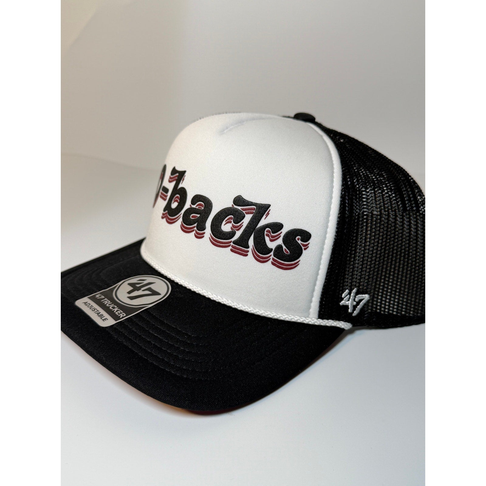 Black and white 47 Brand Arizona Diamondbacks trucker hat with adjustable strap, featuring team logo on front.