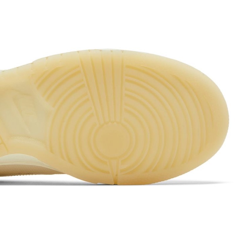 Nike Dunk Low women's sneakers in gold and white, featuring a sleek design with Nike branding and white laces.