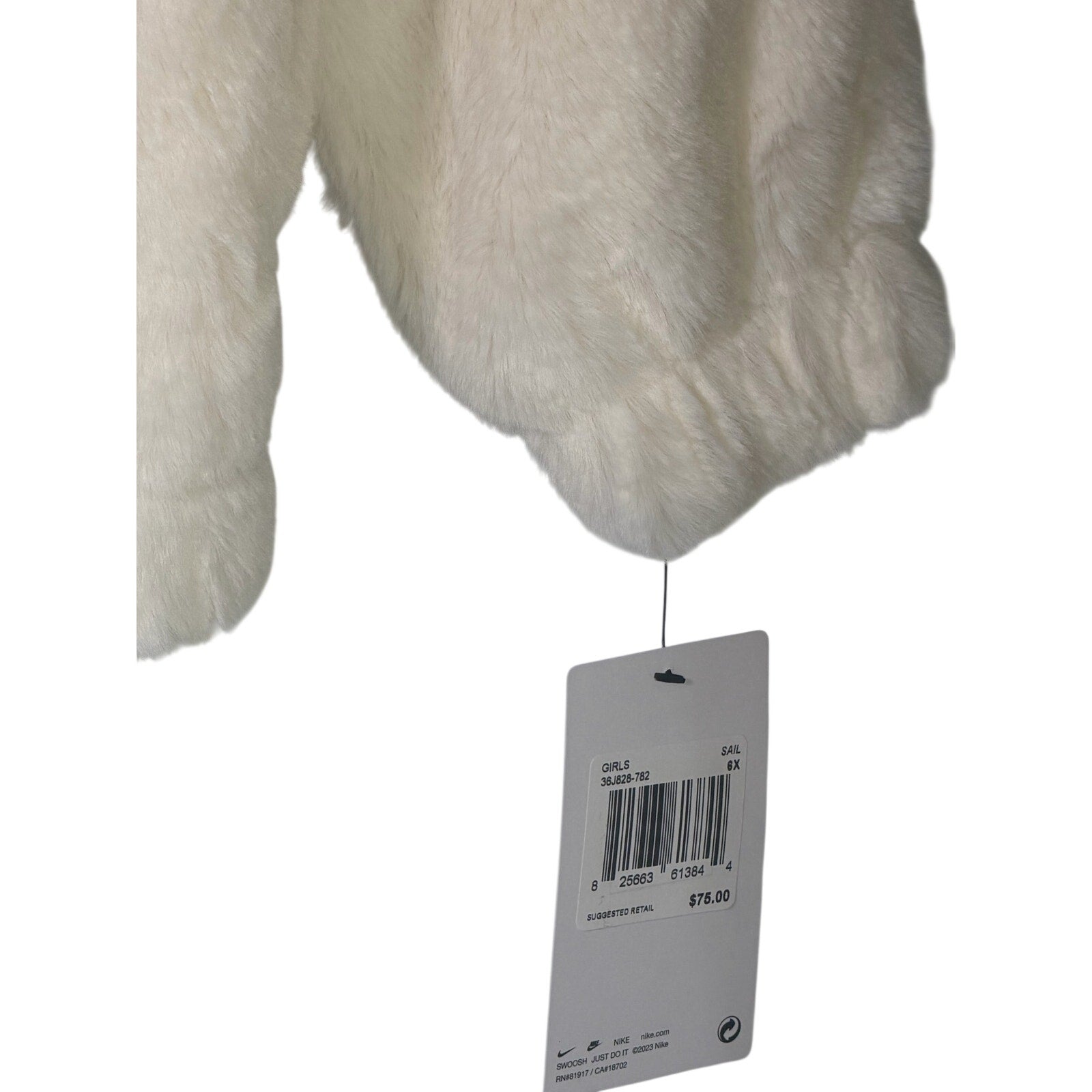 Nike girls' faux fur full zip jacket in cream and black, size 6X, featuring an oversized swoosh logo and plush design.
