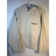 Fear of God ESSENTIALS men's Light Oatmeal pullover hoodie with logo, front view, showcasing casual sweatshirt design.