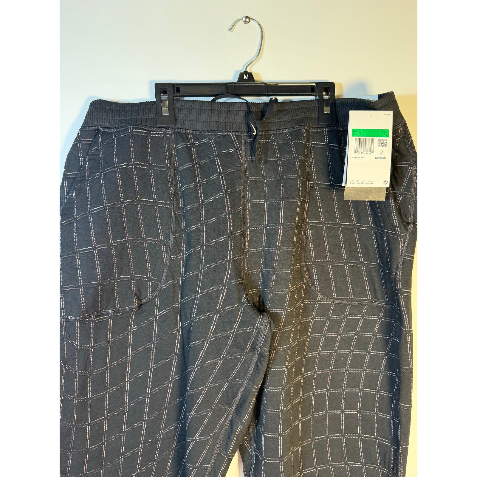 Nike Women's Yoga Luxe Grid Print Jogger Pants in black, showing the stylish relaxed fit and grid pattern fabric.