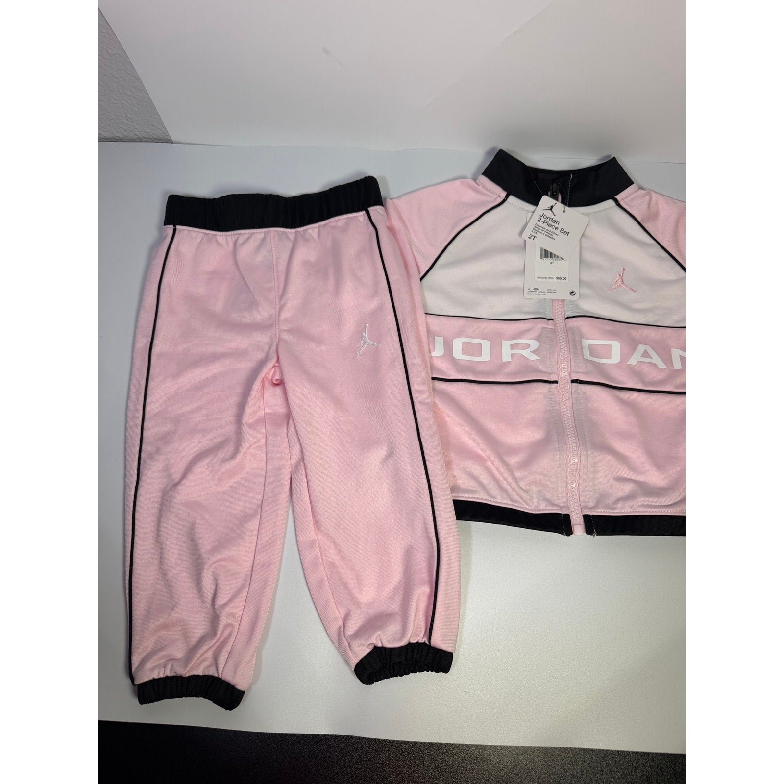Jordan toddler girls pink and black 2-piece track jacket and pants set, size 2T, new with tags, casual athletic clothing.