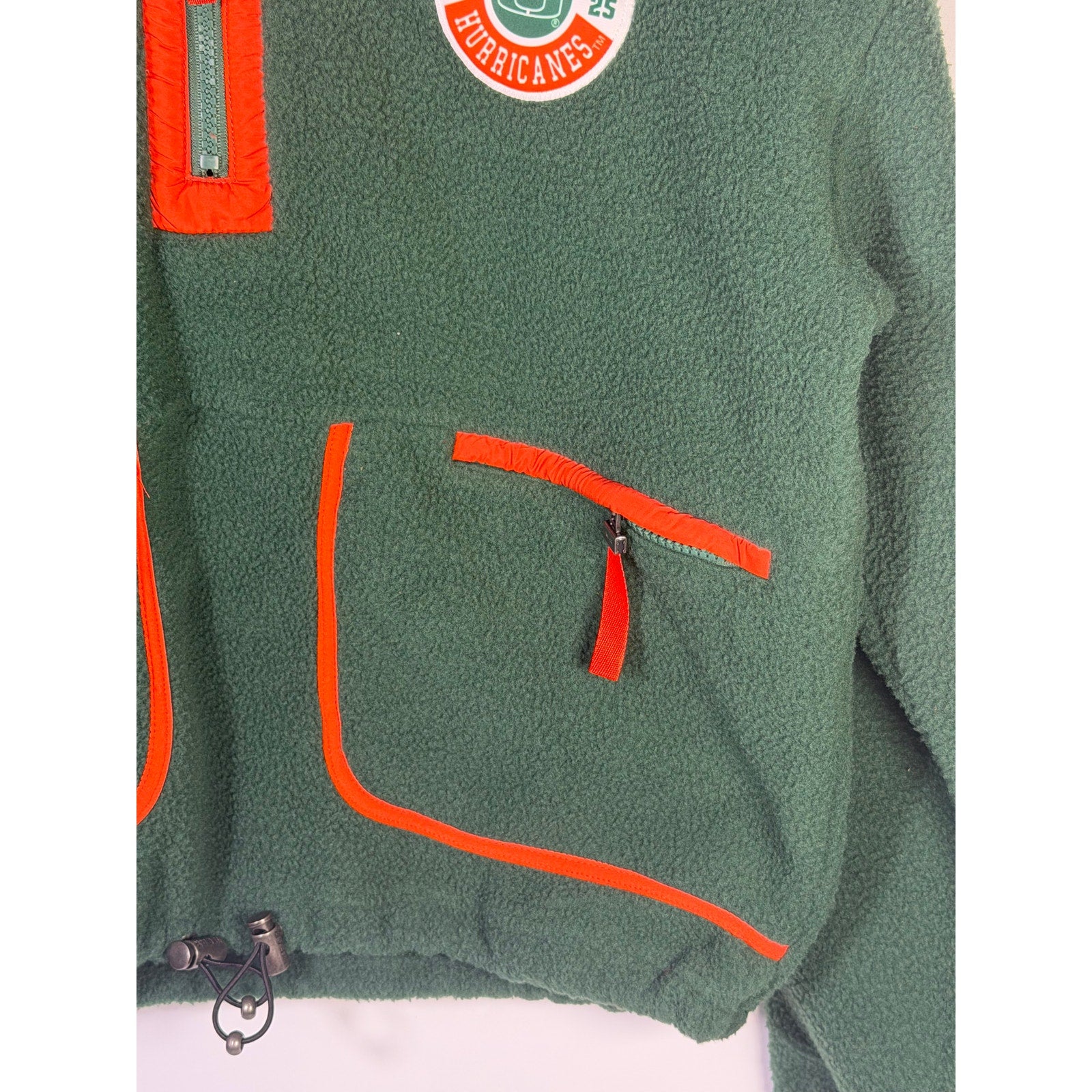 Wear by Erin Andrews women's Miami Hurricanes green quarter-zip fleece sweatshirt, size small, shown on a hanger.