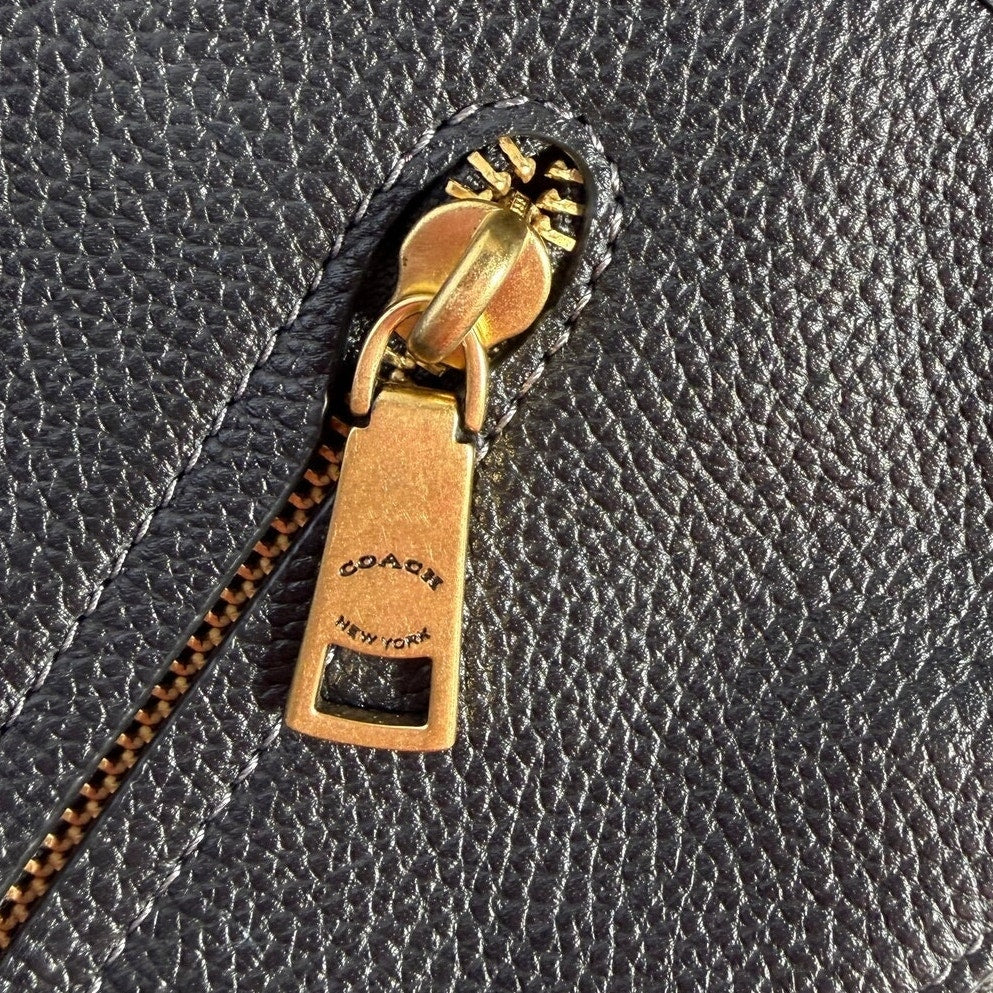 Coach women's black pebbled leather crossbody handbag with gold-tone hardware, stylish shoulder bag for everyday use.