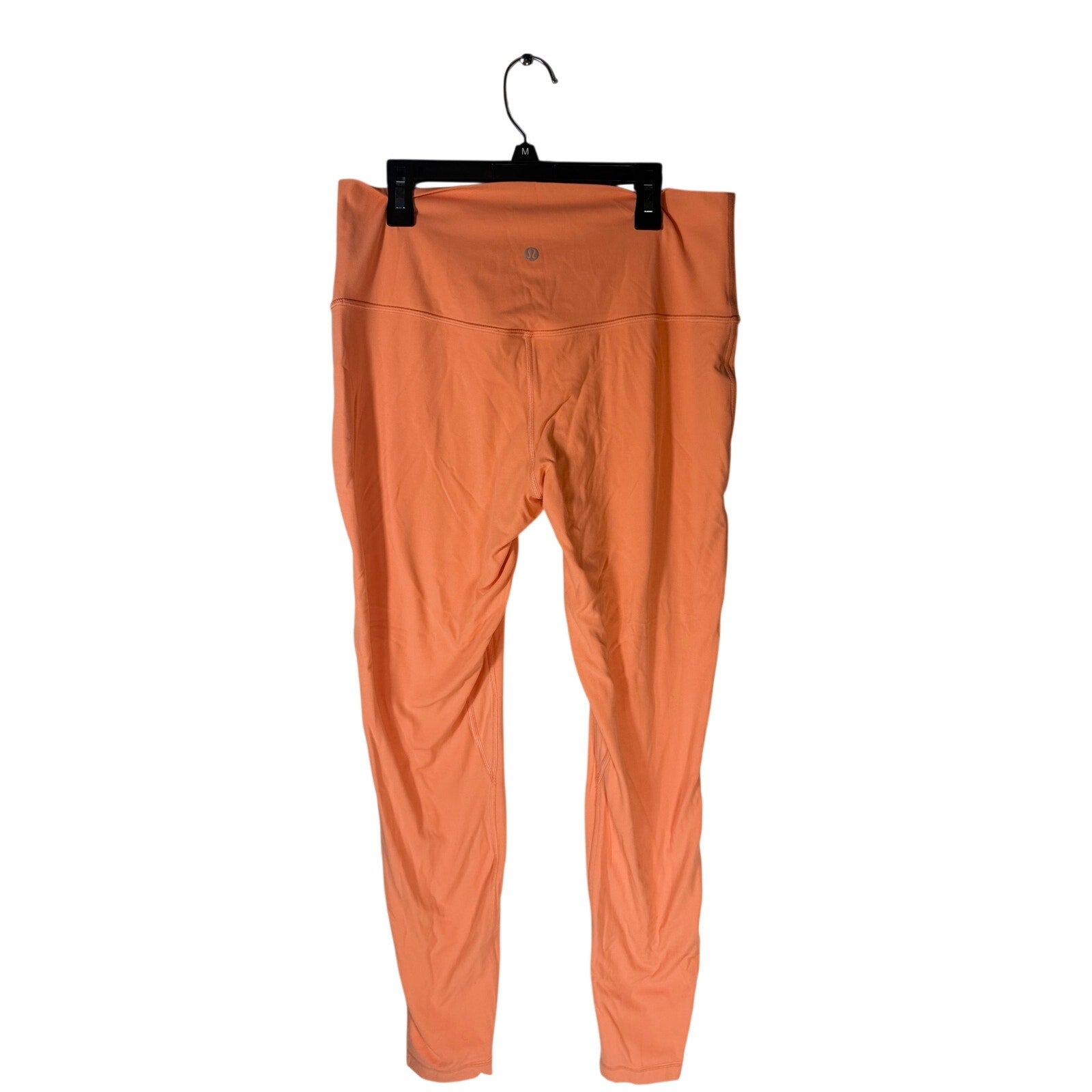 Lululemon women's high-rise burnt orange leggings in size 12, fitted and stretchy for active wear or casual styling.
