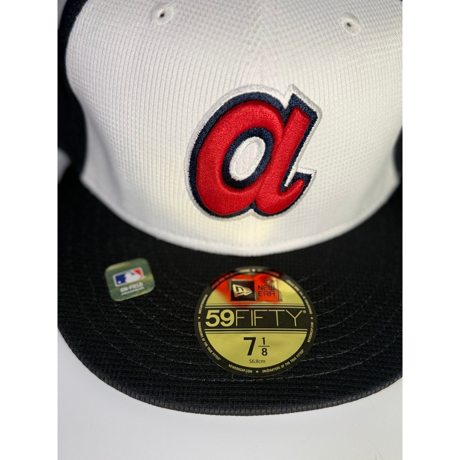 New Era Atlanta Braves 59FIFTY fitted cap in white and black, size 7 1/8, MLB team hat with structured design.