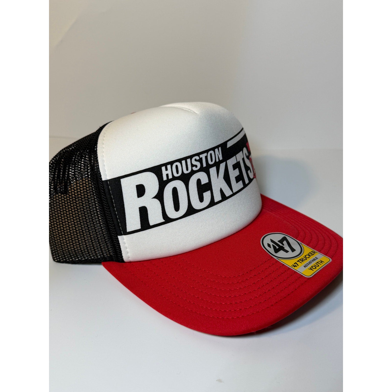 Red and black 47 Brand Houston Rockets youth trucker snapback hat with adjustable strap and team logo front panel.