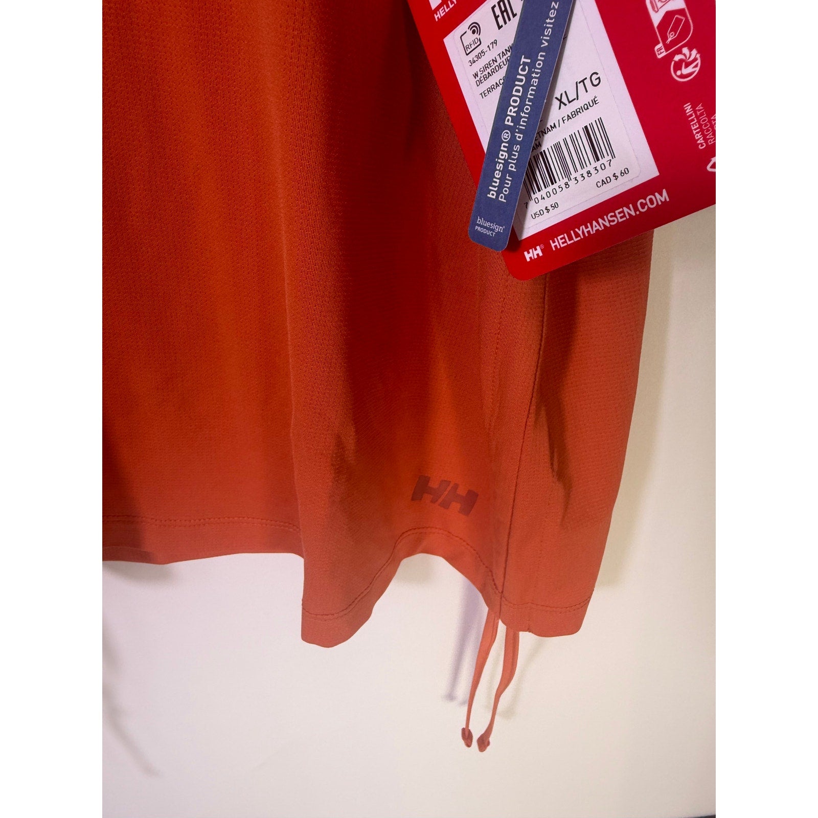 Helly Hansen women's orange active tank top with sleeveless design and drawstring hem, ideal for sports and workout activities.