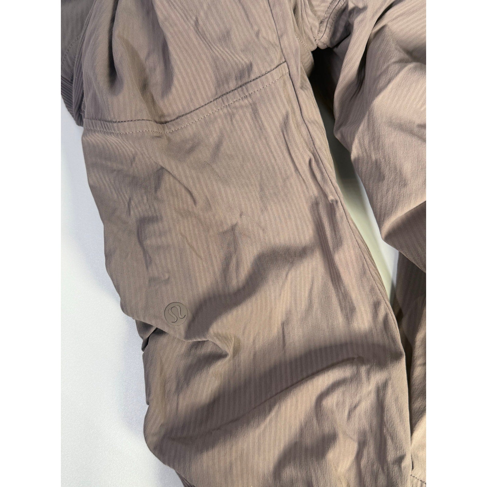 Lululemon women’s high-rise taupe gray tapered pants with ruched detail, size 4, preowned, shown on a model.