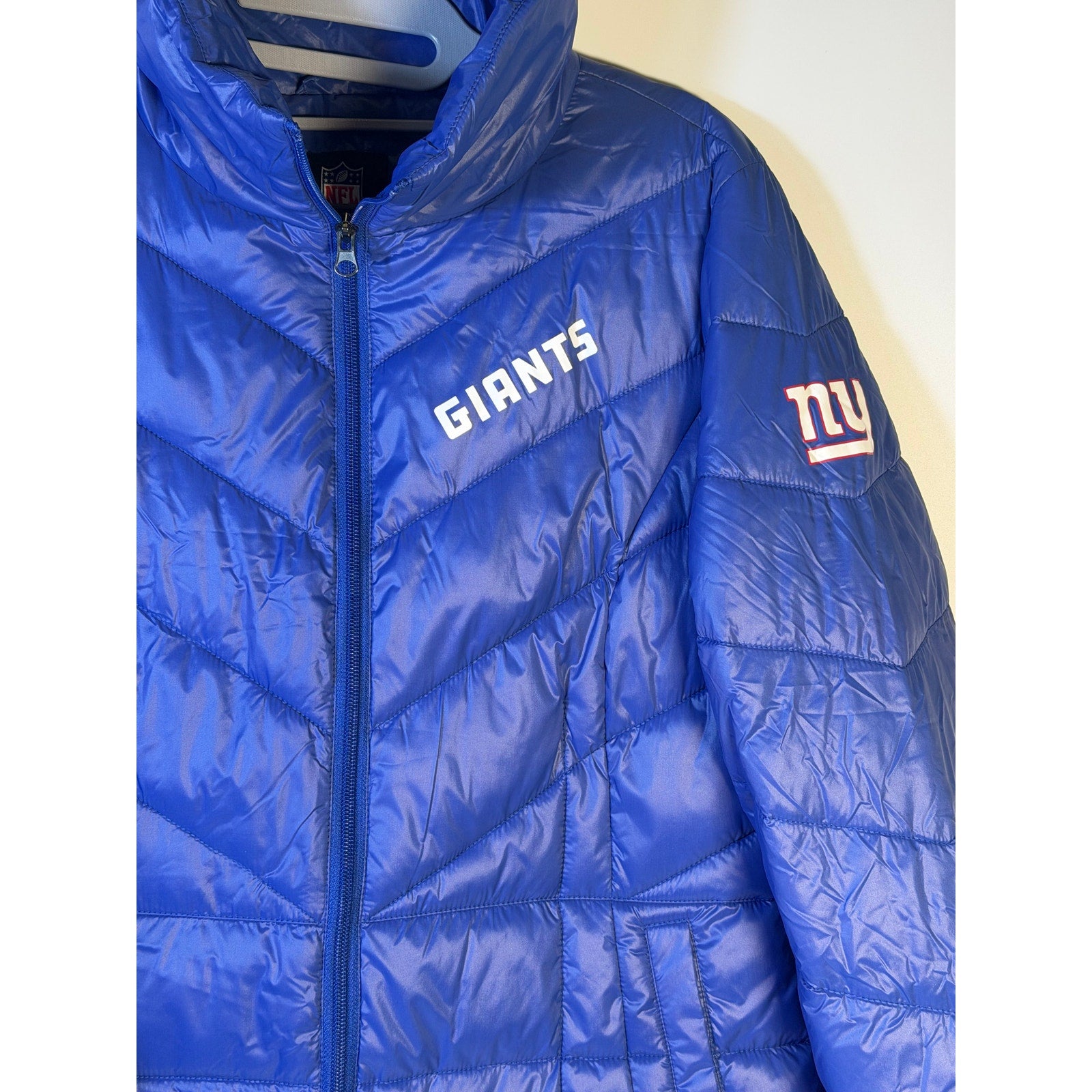 NFL New York Giants women's blue puffer jacket with full zip, medium size, featuring team logo and quilted design.