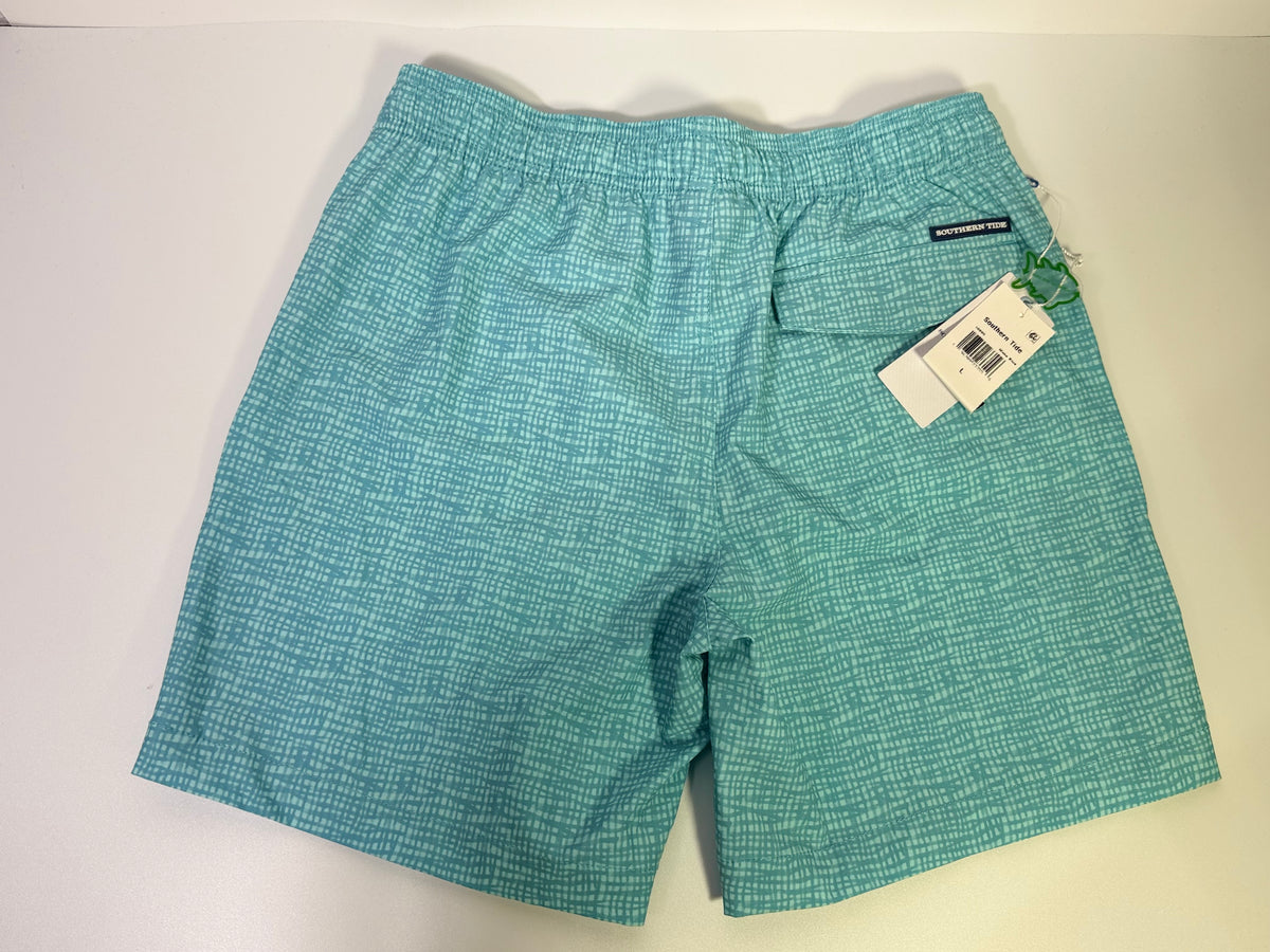 Southern Tide teal printed performance swim trunks laid flat, showing the vibrant pattern and adjustable waistband.