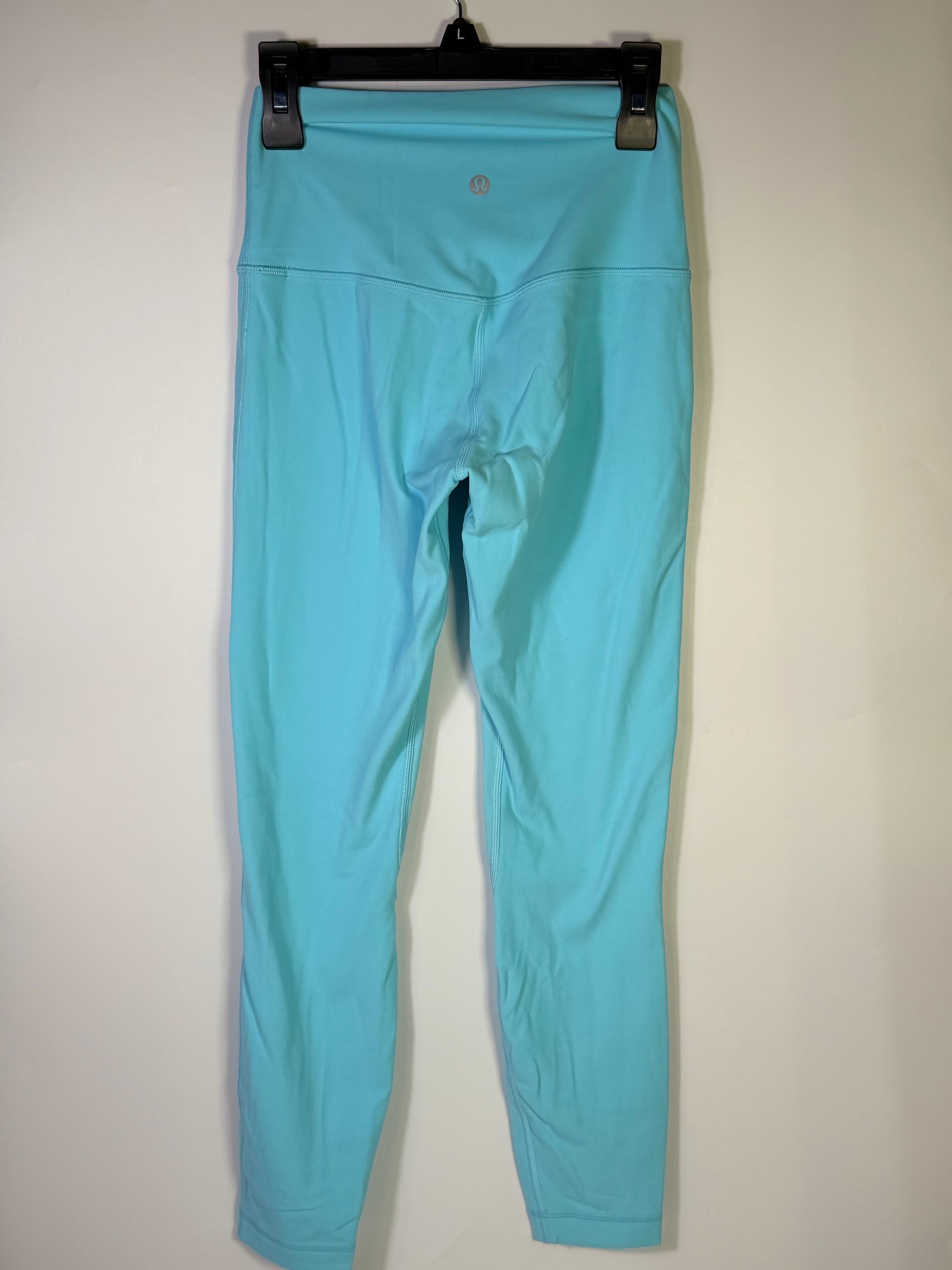 Lululemon women's size 4 aqua blue high-rise full-length leggings laid flat, showcasing the stretchy, smooth fabric and high waistband.